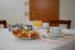 巴斯蒂亚乌姆布拉P＆P阿西西卡麦里酒店的一张桌子,上面放着一盘面包和一杯橙汁