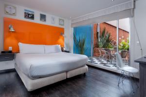 波哥大104艺术套房蓝色大门酒店 的一间带一张白色大床的卧室和一个阳台