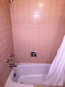 韦尔斯Sharon Motel的浴室配有粉红色瓷砖和浴缸