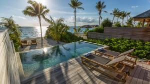 古丽都胡拉瓦西岛度假村的一个带2把躺椅的游泳池和海洋