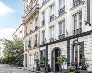 巴黎波西米亚别墅酒店的街道上种有盆栽植物的白色建筑
