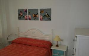 埃尔卡沃德加塔Apartamento Los Flamencos的卧室墙上有三张猫的照片