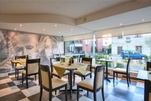 圣地亚哥普罗维登斯欧洲电信酒店的餐厅设有桌椅和大窗户。