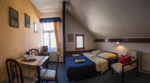 尼萨河畔亚布洛内茨巴扎卡旅馆的卧室配有一张床和一张桌子及椅子