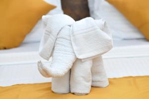 达瓦拉维翠景旅行度假旅馆的床上的白色毛巾,大象塞在床上