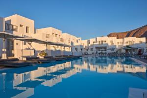 佩里萨水蓝色海滩酒店的享有带白色建筑的度假村游泳池的景致