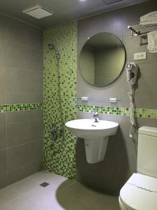 嘉义市万泰大饭店的一间带水槽、淋浴和镜子的浴室