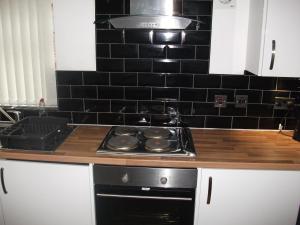 米德尔斯伯勒The Grange的厨房配有炉灶和黑色瓷砖墙。