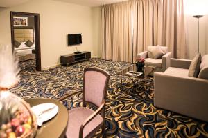 阿布扎比阿联酋广场酒店的酒店客房设有带沙发和椅子的起居区。