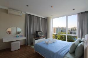 华欣My Resort Huahin by MR.JAY的一间卧室设有蓝色的床和大窗户