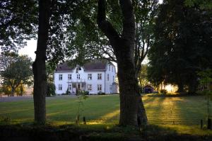 Vreta KlosterSödra Lund B&B的前面有树木的大白色房子
