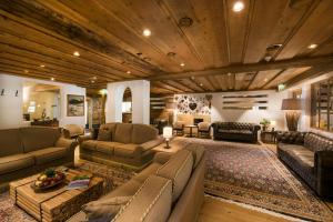 蒂罗尔-泽费尔德鸿扯德酒店的客厅配有皮革家具和木制天花板