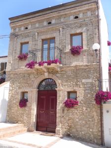奥托纳La Casa Del Palombaro的一座红色门和紫色花的建筑