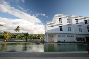 帝力拉姆劳酒店的建筑前的一座带游泳池的建筑