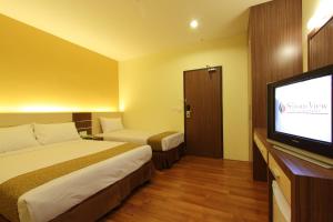 关丹季节景观酒店的配有一张床和一台平面电视的酒店客房