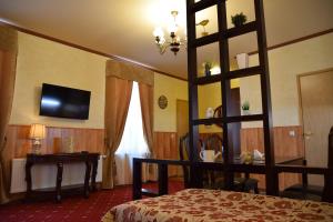 塔尔图Hansa Apartment的酒店客房配有一张床、一张书桌和一台电视。