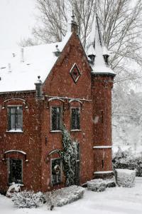 斯帕Un Air de Château的一座红砖房子,里面积雪