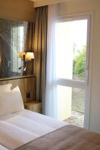 圣米歇尔山圣奥伯特酒店的一间卧室设有一张床和一个大窗户