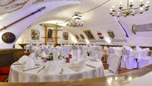 瓦瑟堡瓦瑟堡城堡酒​​店的宴会厅配有白色的桌椅