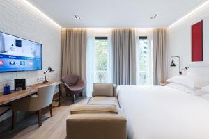 巴塞罗那考奈尔酒店的一间卧室配有一张床、一张书桌和一台电视。