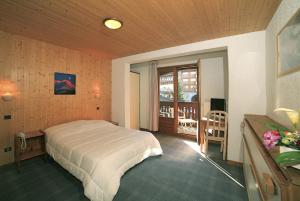 谷雪维尔Hotel Club Blanche Neige的一间带大床的卧室和一个阳台