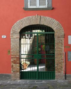 巴尼奥雷焦波丽妮雅住宿加早餐旅馆的红色建筑前的绿色大门