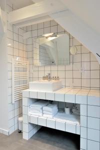 布里夫拉盖亚尔德Hôtel Le Collonges TV connecté wifi Netflix的白色的浴室设有水槽和镜子