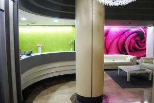 萨拉戈萨阿尔加河酒店的一个带沙发和粉红色墙壁的大堂