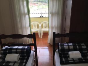 欧鲁布兰科Hostel Rotor的带窗户的客房内的两张床和椅子