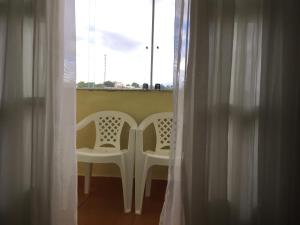 欧鲁布兰科Hostel Rotor的带窗户的客房内的两把白色椅子