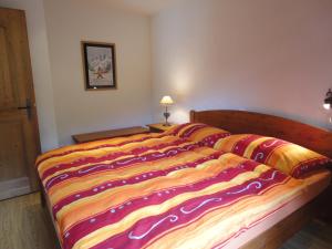 尚佩里Chalet Hestia的一张床上有五颜六色的毯子,放在房间里