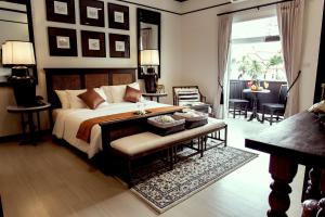 清迈99号遗产酒店-SHA Extra Plus Certified的一间卧室配有一张带长凳和桌子的床