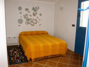 巴尔巴特尔微罗德拉立维尔拉公寓的一间卧室配有一张带橙色毯子的床