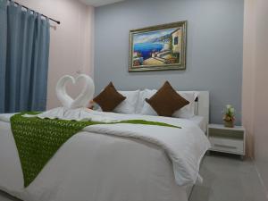 奈扬海滩普莱德65号旅馆的卧室配有白色的床和天鹅