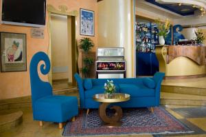 里米尼拉格拉迪斯卡酒店的大堂设有蓝色的沙发和桌子