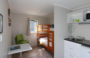 新普利茅斯菲茨罗伊海滩假日公园露营地的一间小房间,配有双层床和厨房