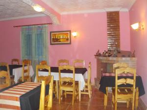 菲亚纳兰楚阿Rem Hotel的用餐室设有粉红色的墙壁和桌椅