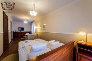 斯维诺乌伊希切威拉阿泰纳卢酒店的卧室配有一张带白色床单和枕头的大床。