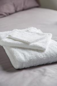 圣吉欧梅斯珍珠公寓的床上的白色毛巾堆