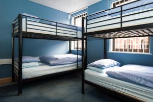 利兹罗素斯科特背包客旅舍的蓝色墙壁的客房内设有两张双层床。