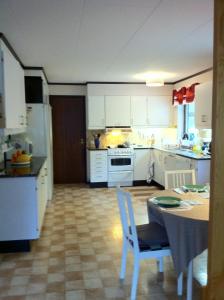 博伦厄巴尔布鲁9号民宿的厨房配有白色橱柜和桌椅