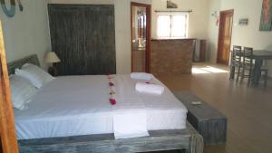 拉迪格岛珊瑚公寓旅馆的一间卧室配有一张大床和毛巾