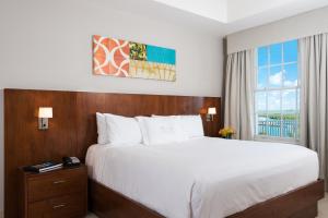 格雷斯湾Blue Haven Resort- All Inclusive的一间卧室设有一张大床和一个窗户。