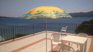 维甘Holiday Home Smokvica的阳台配有桌椅和遮阳伞