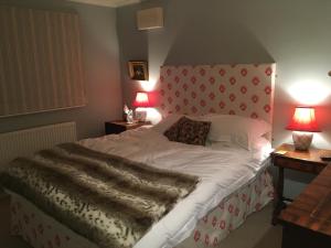 MaidfordYew Tree Cottage的一间卧室配有一张大床和红色床头板