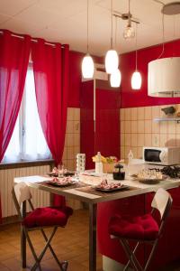 San Fermo della Battaglia蜂蜜住宿加早餐旅馆的厨房配有红色窗帘和桌椅