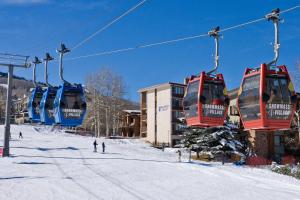 斯诺马斯村Mountain Chalet Snowmass的滑雪坡上带蓝色和红色椅子的滑雪缆车