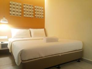 吉隆坡1000英里酒店的一间卧室配有带白色床单和枕头的床。