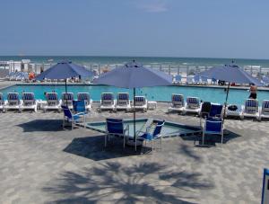 新士麦那海滩新士麦那海滩岛屿海滩度假酒店的海滩上的一组桌椅和遮阳伞