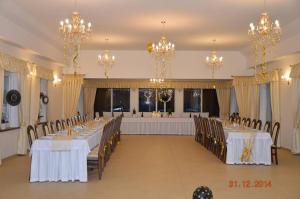 Nowogródek PomorskiZielona Dolina的宴会厅配有桌椅和吊灯